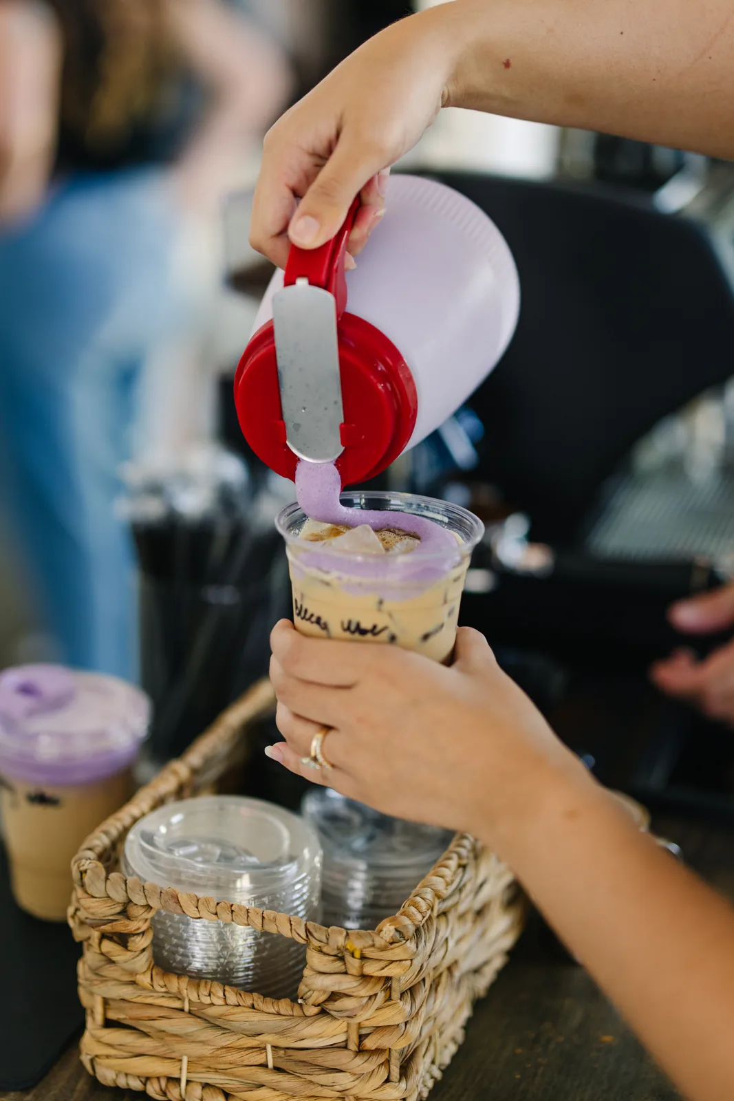 A Sunrise iced drink receiving a colorful cold-foam topping